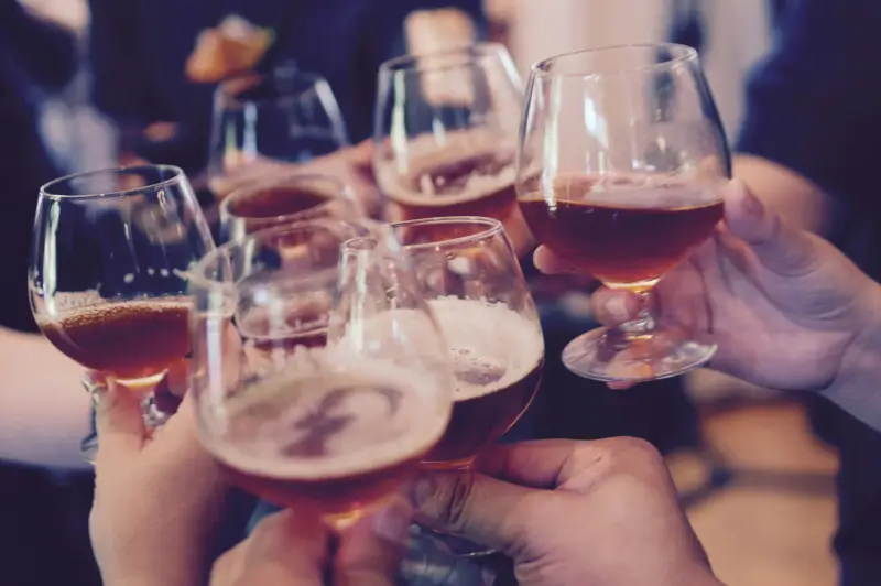 several hands clinking beer glasses
