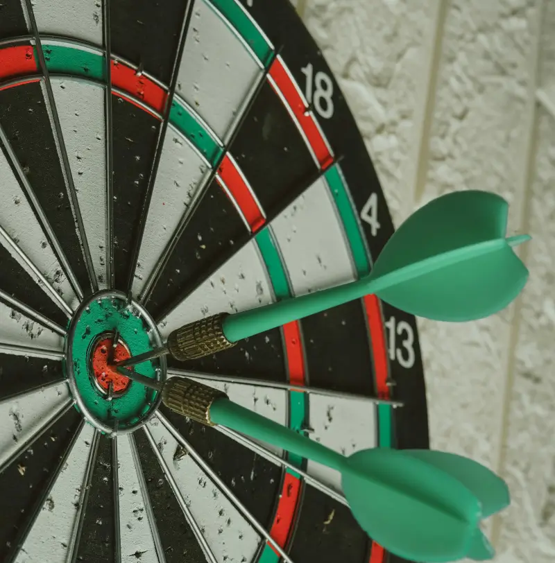 a dartboard with 2 darts in the center of the bullseye